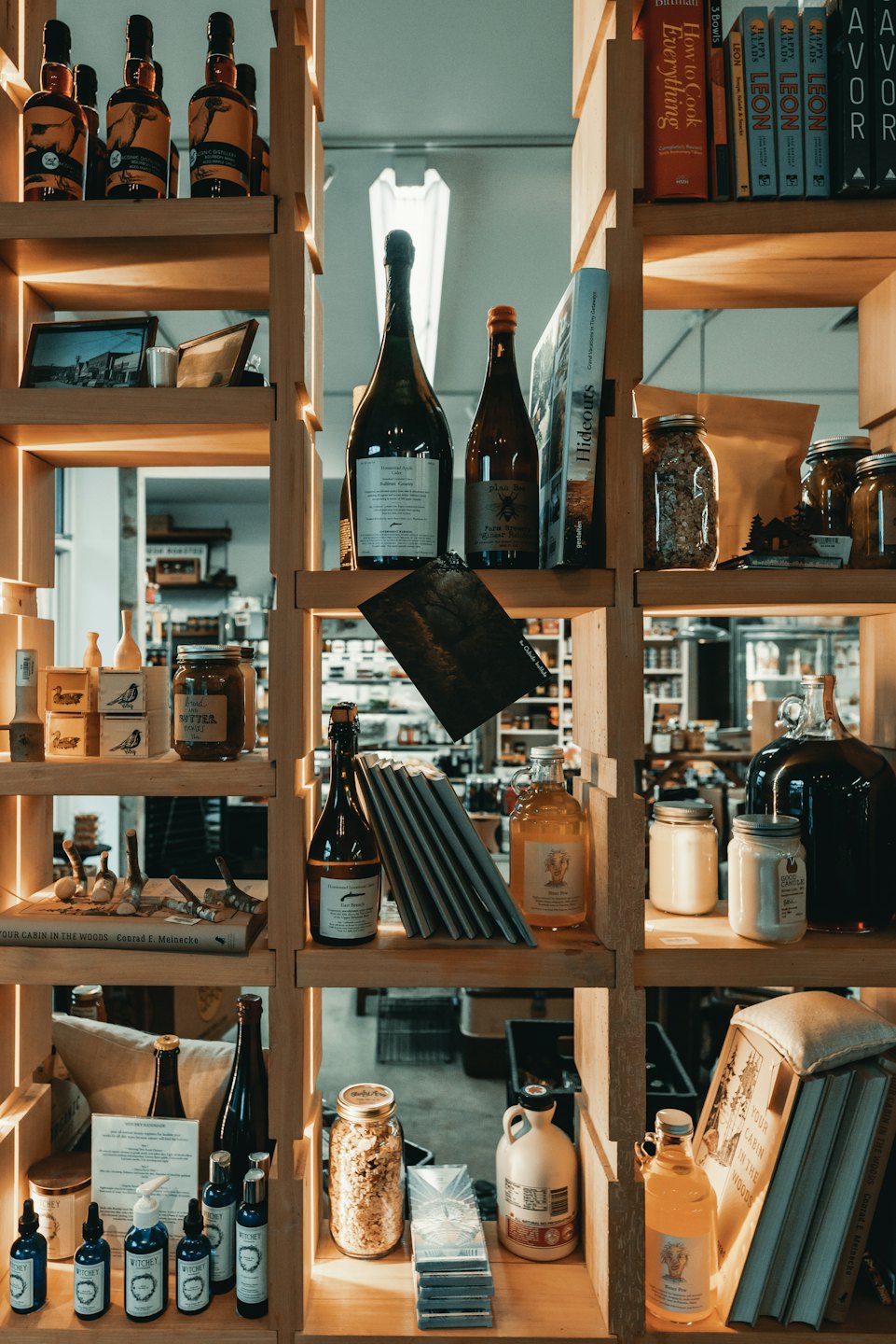 Wooden shelf displays artisanal food, drinks, and home goods.
