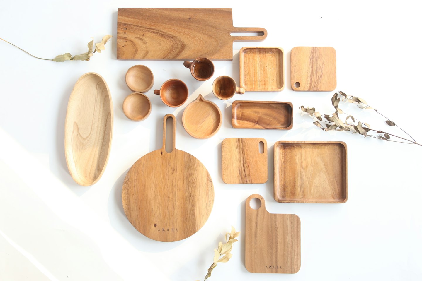 Natural wood kitchen items arranged on a white surface.