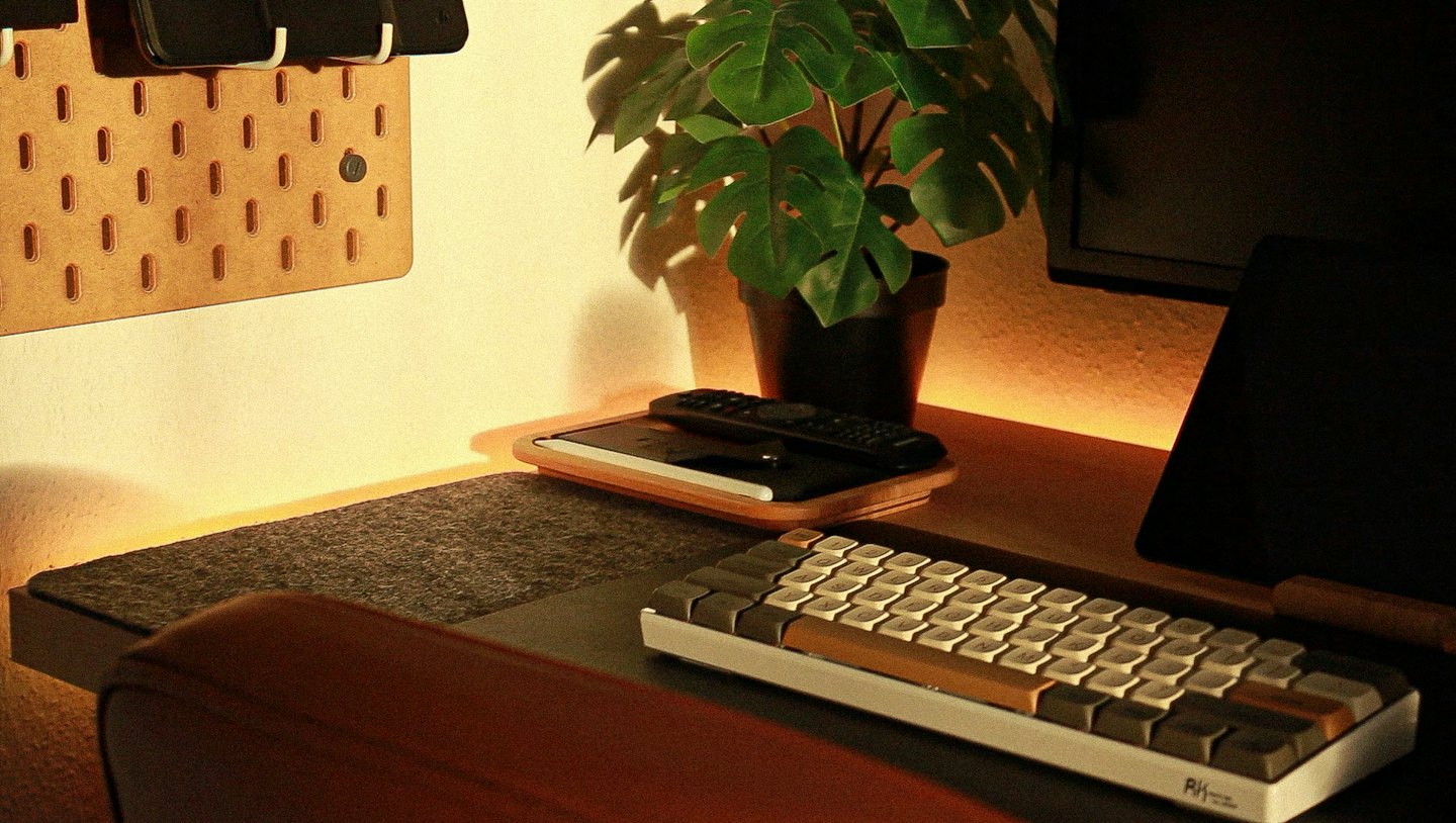 Organized wooden desk with a mechanical keyboard and smartphone pegboard.